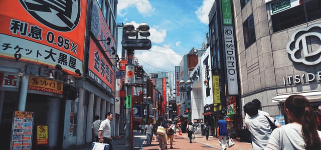 도쿄 시부야 센터가 거리의 화려한 일본어 간판들과 좁은 골목을 가득 채운 보행자들의 활기찬 모습이 담긴 풍경입니다.