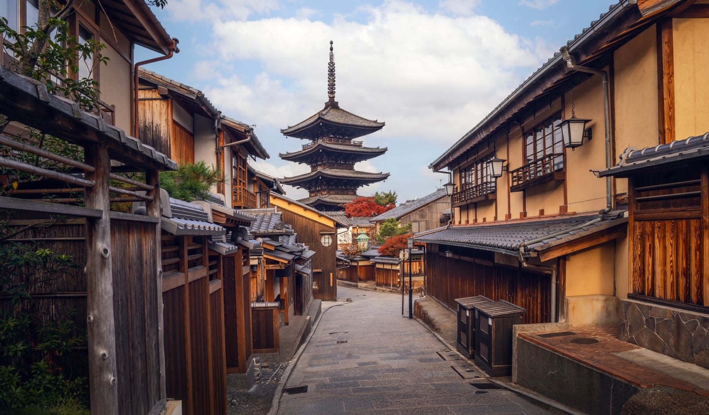 교토 히가시야마의 고풍스러운 목조 가옥들 사이로 웅장하게 솟아오른 야사카의 탑과 정겨운 돌담길이 어우러진 풍경입니다.
