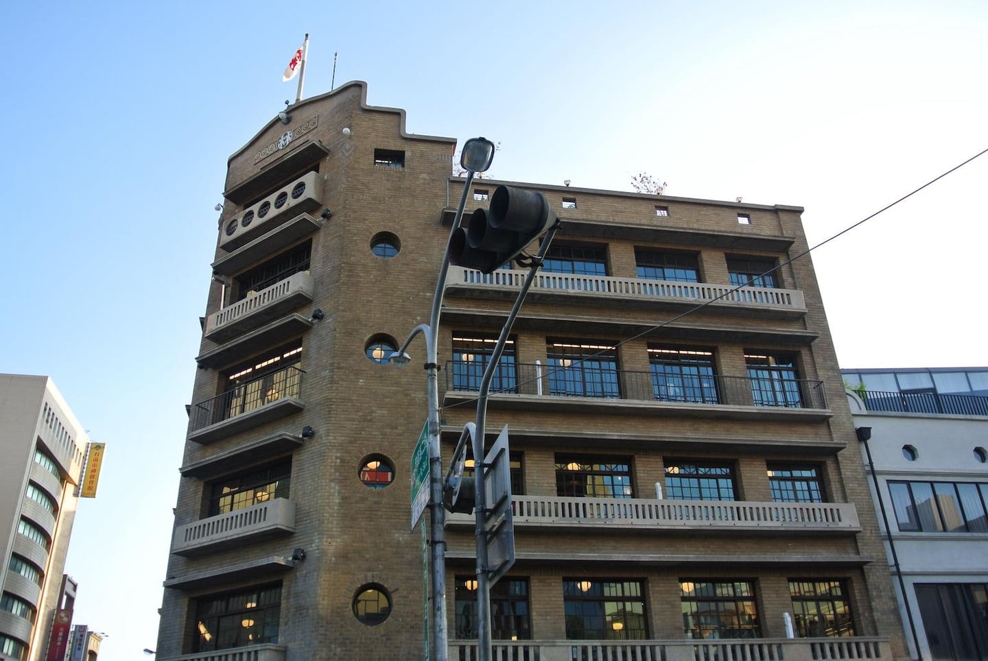 타이난의 명소인 하야시 백화점의 고전적인 갈색 벽돌 외관과 독특한 원형 창문이 돋보이는 근대 건축물의 전경입니다.