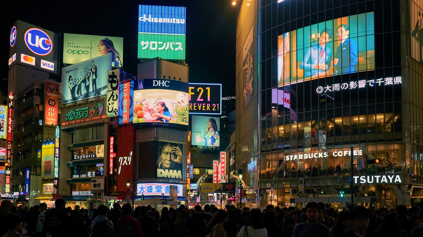 화려한 네온사인과 대형 전광판 광고가 가득한 도쿄 시부야의 밤거리에서 수많은 사람들이 횡단보도를 건너며 활기찬 도시의 야경을 만들어내고 있습니다.