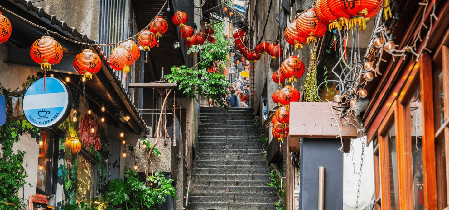 붉은 홍등이 화려하게 빛나는 대만 지우펀의 좁은 돌계단 골목길과 고풍스러운 건물들이 어우러진 이국적인 야경 풍경입니다.