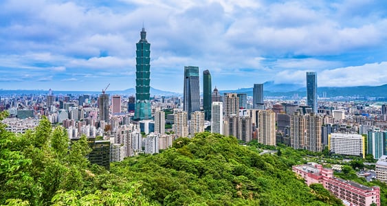 울창한 초록빛 산 뒤로 타이베이 101 타워와 현대적인 고층 빌딩들이 펼쳐진 대만 타이베이의 시원한 도시 파노라마 전경입니다.