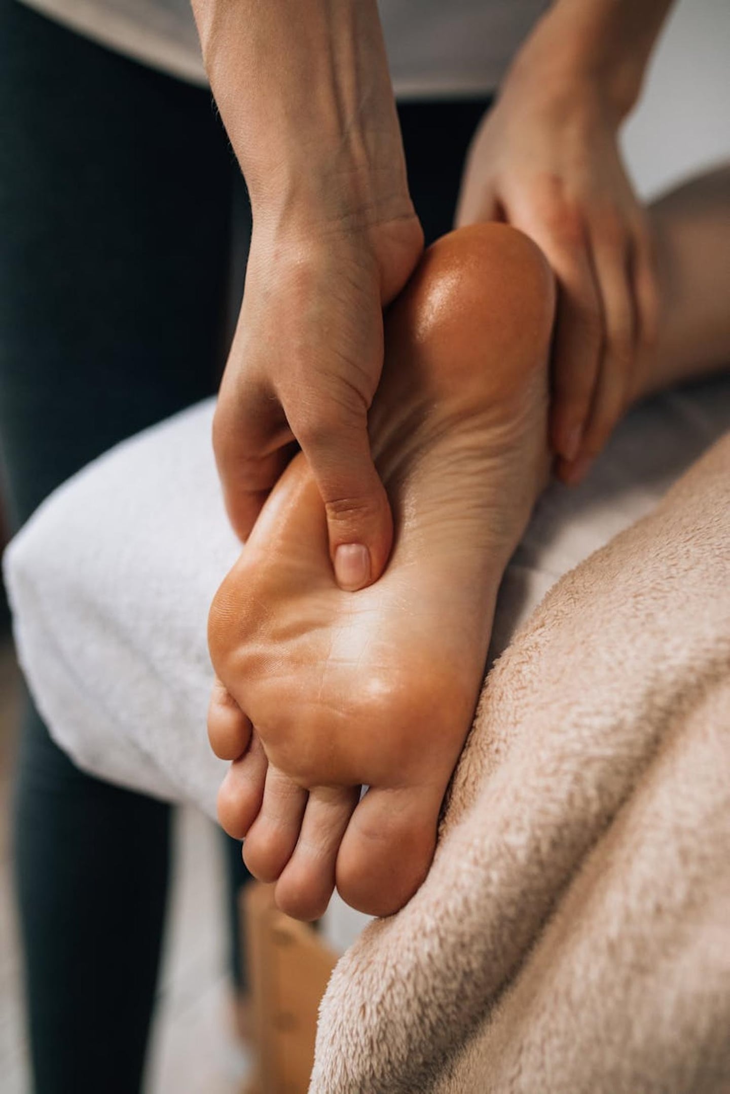오일이 발라진 매끄러운 발바닥을 전문적인 손길로 지압하며 피로를 풀어주는 발 마사지 서비스의 상세한 모습입니다.