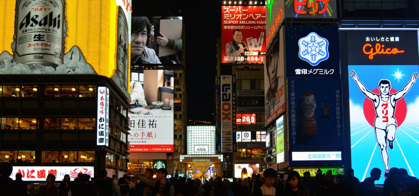 오사카 도톤보리의 상징인 글리코상 전광판과 화려한 네온사인 간판들이 가득한 밤거리에서 인파가 붐비는 활기찬 야경 모습입니다.