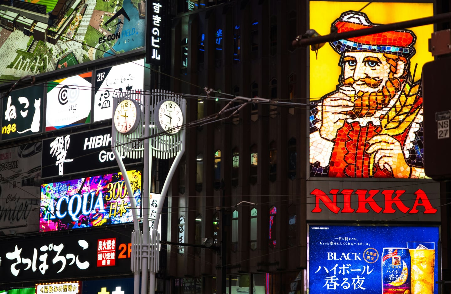 삿포로 스스키노의 상징인 니카 위스키 전광판과 화려한 네온사인 간판들이 밤거리를 밝히고 있는 활기찬 일본 도시 야경 모습입니다.