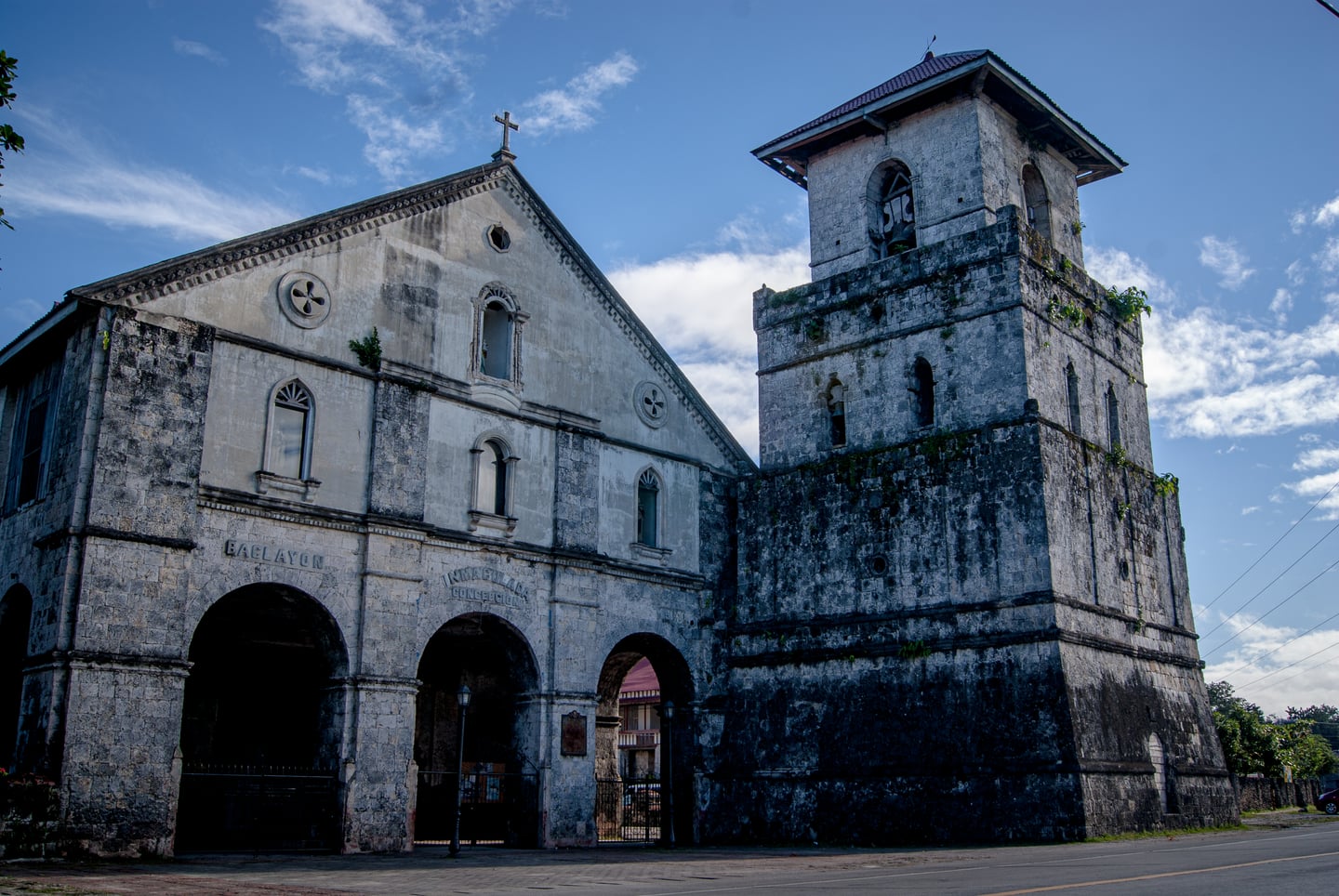 푸른 하늘을 배경으로 서 있는 필리핀 보홀 바클레욘 성당의 웅장한 석조 외벽과 높은 종탑이 조화를 이루는 역사적인 풍경입니다.
