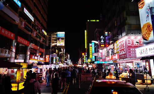 화려한 네온사인 간판이 가득한 대만의 밤거리 야시장에서 수많은 사람들이 노점상을 구경하며 걷고 있는 활기찬 풍경입니다.