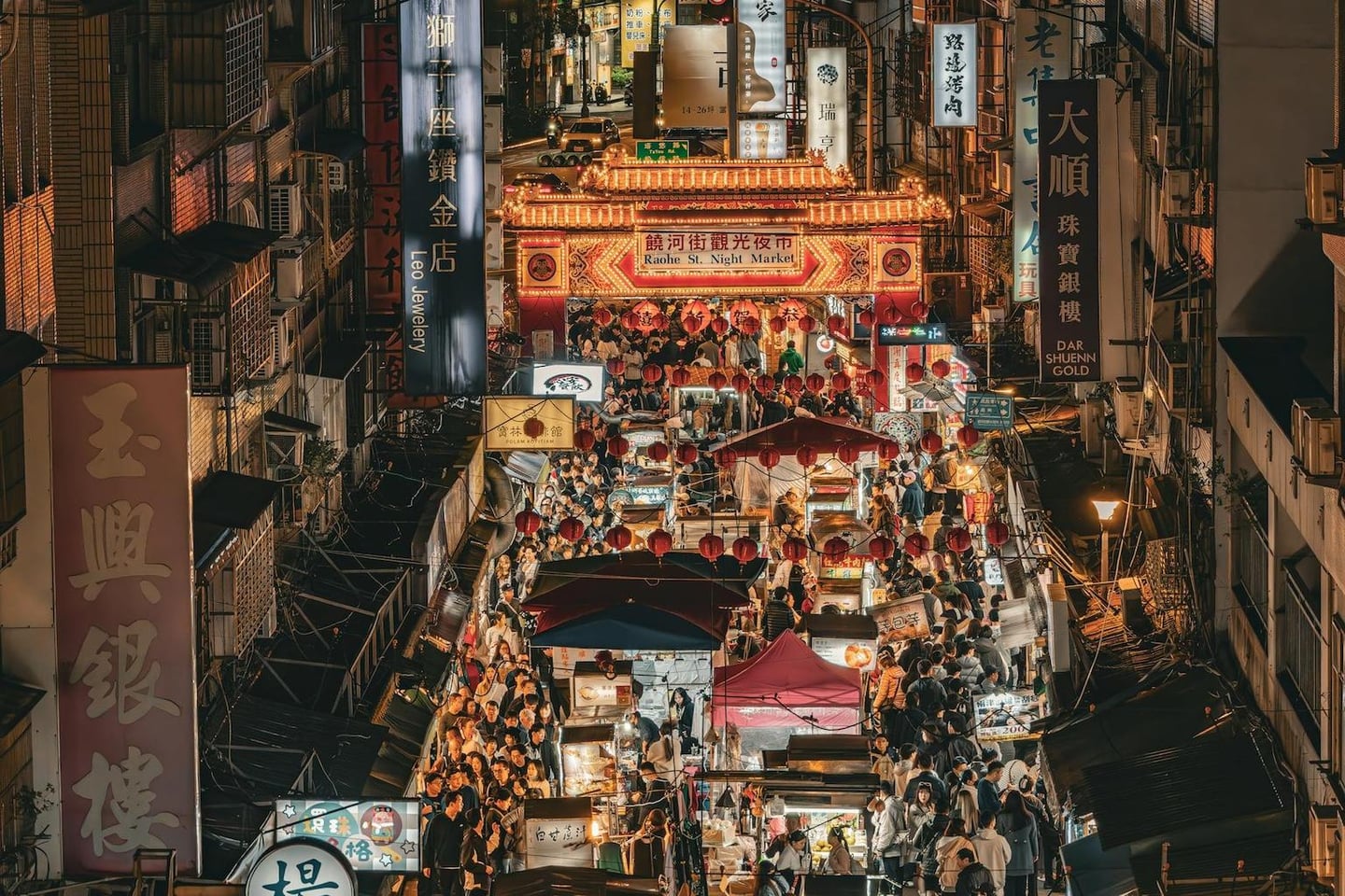 화려한 조명이 켜진 라오허제 야시장 입구 아래로 수많은 사람들이 붐비는 대만 타이베이의 활기찬 밤거리 풍경입니다.