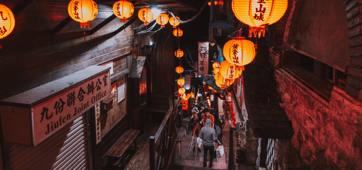 붉은 홍등이 가득 켜진 대만 지우펀의 좁은 계단 골목길에서 밤거리를 즐기며 걷고 있는 관광객들의 모습입니다.