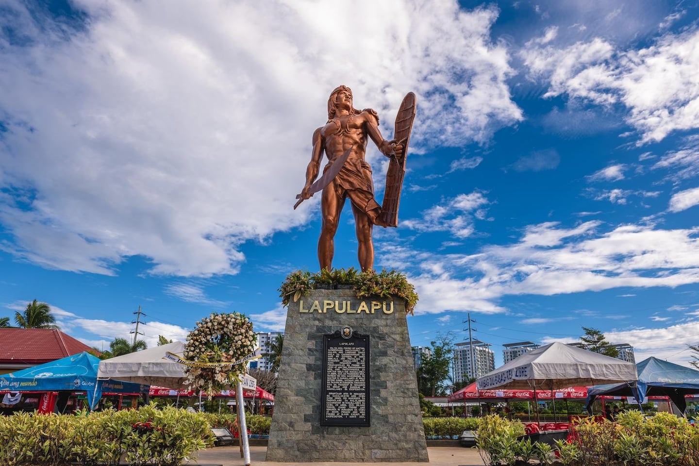 필리핀 세부 막탄섬의 랜드마크인 라푸라푸 기념비가 맑은 하늘 아래 칼과 방패를 든 웅장한 청동상 모습으로 세워져 있습니다.