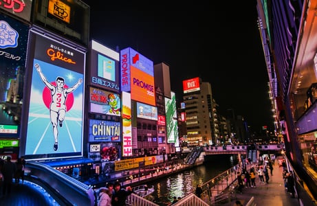 오사카 도톤보리 운하를 따라 늘어선 화려한 글리코상 전광판과 네온사인들이 밤하늘 아래 밝게 빛나며 활기찬 도시 야경을 연출합니다.