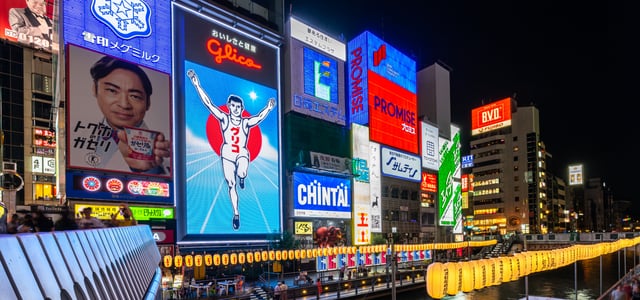 오사카의 상징인 글리코상 전광판과 화려한 네온사인 광고들이 도톤보리 강변 건물을 가득 채운 활기찬 밤 풍경입니다.