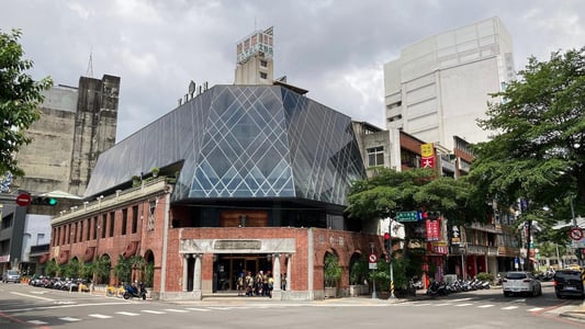 붉은 벽돌의 고전미와 현대적인 유리 구조물이 조화를 이루는 대만 타이중 궁원안과 건물의 전경으로 거리의 활기찬 분위기가 느껴집니다.