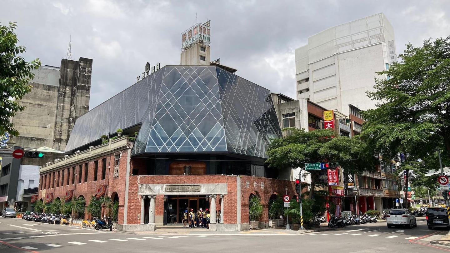 붉은 벽돌의 고전미와 현대적인 유리 구조물이 조화를 이루는 대만 타이중 궁원안과 건물의 전경으로 거리의 활기찬 분위기가 느껴집니다.