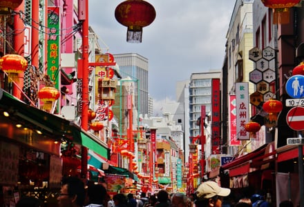 고베 난킨마치, 붉은 홍등과 화려한 상점 간판들이 가득한 차이나타운 거리의 활기찬 낮 풍경입니다.