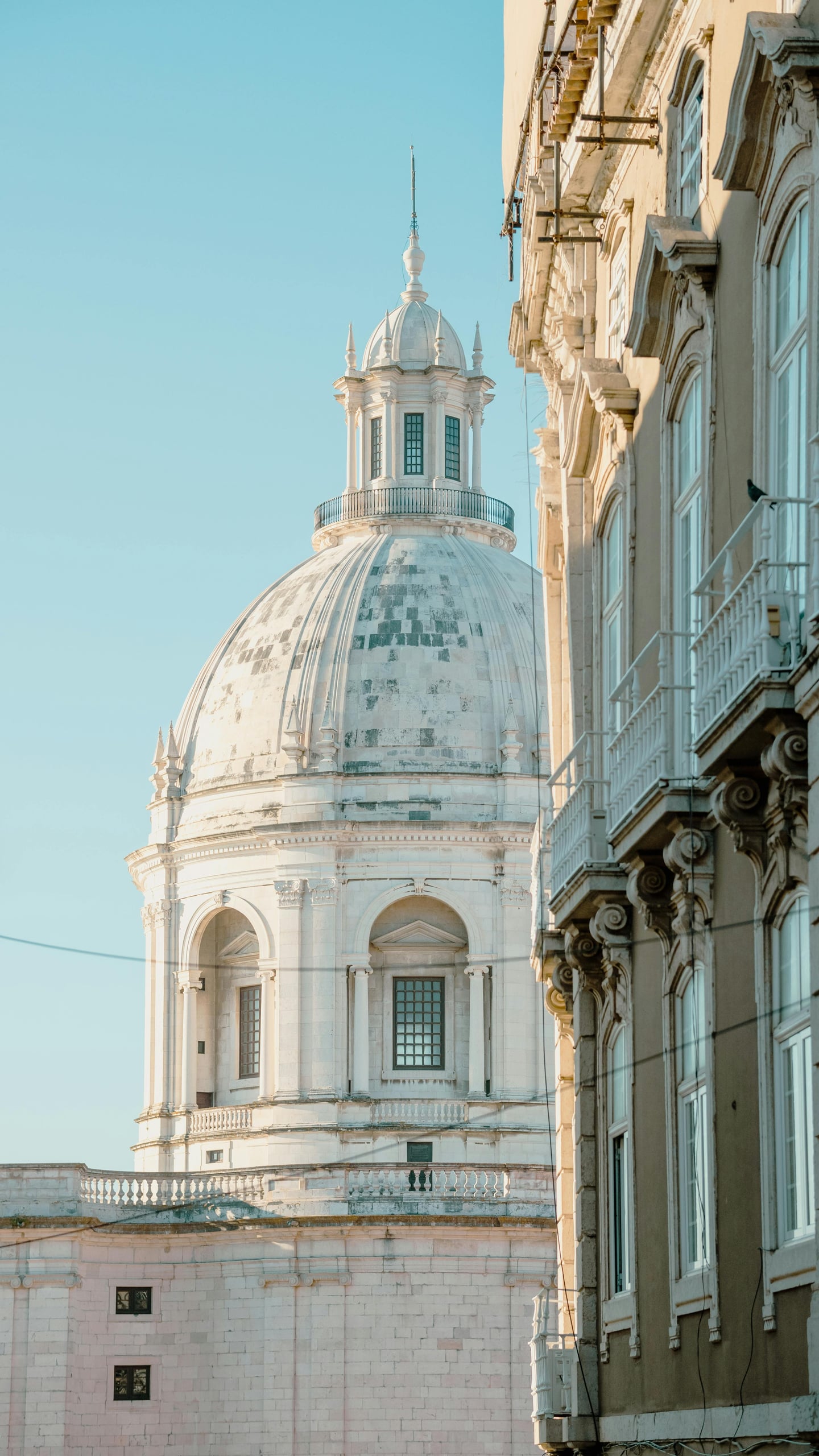 리스본 국립 판테온, 맑은 하늘 아래 우뚝 솟은 거대한 흰색 돔과 고전적인 석조 건축물의 정교한 디테일이 조화를 이룹니다.