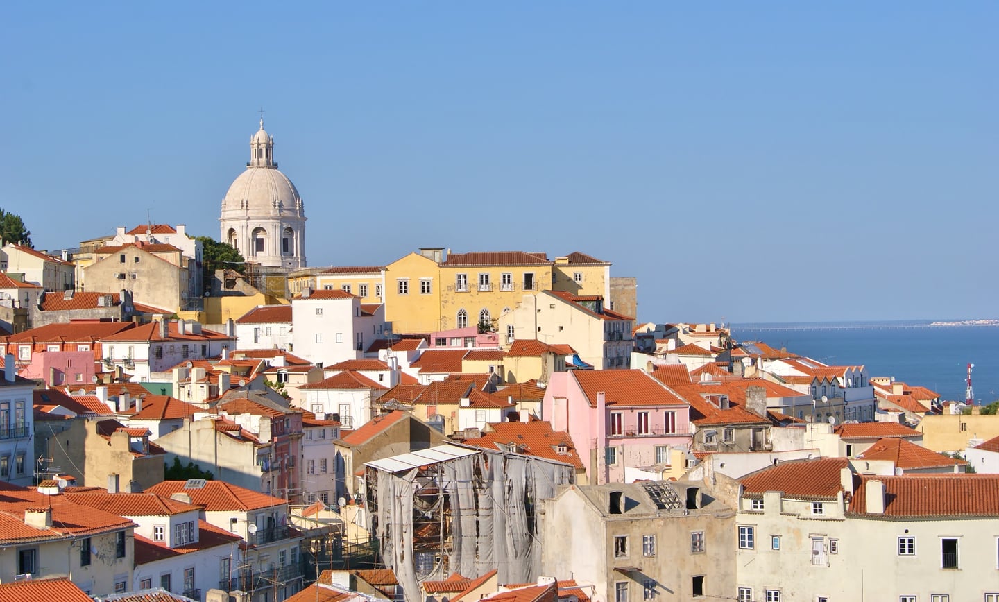 리스본 국립 판테온, 붉은 지붕이 가득한 알파마 지구 너머로 보이는 웅장한 흰색 돔과 푸른 타구스 강의 조화로운 풍경입니다.