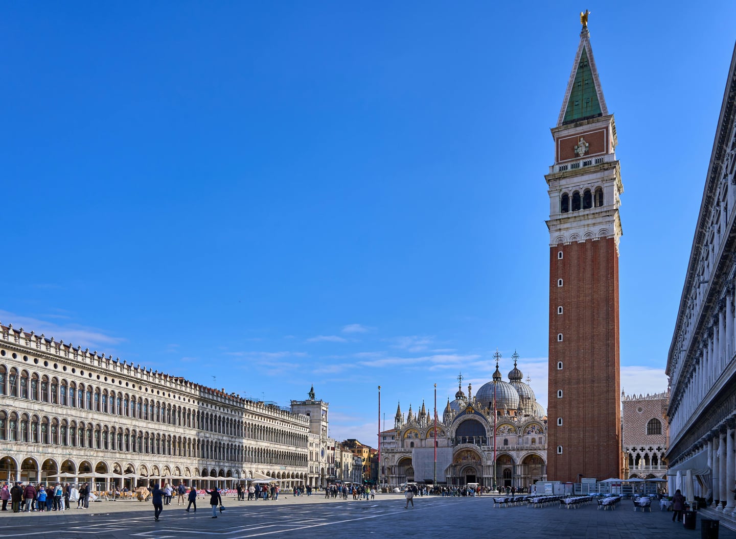 베니스 산 마르코 광장, 푸른 하늘 아래 우뚝 솟은 종탑과 대성당의 웅장한 건축미가 돋보이는 광장의 전경입니다.