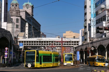 가고시마 시로야마 공원, 전망대 벤치에 앉아 사쿠라지마 화산과 푸른 바다를 감상하는 두 사람의 평화로운 실루엣입니다.
