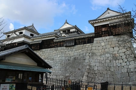 마쓰야마 마쓰야마 성, 거대한 석축 위에 웅장하게 솟아오른 전통 성곽 건물이 푸른 하늘과 어우러진 풍경입니다.