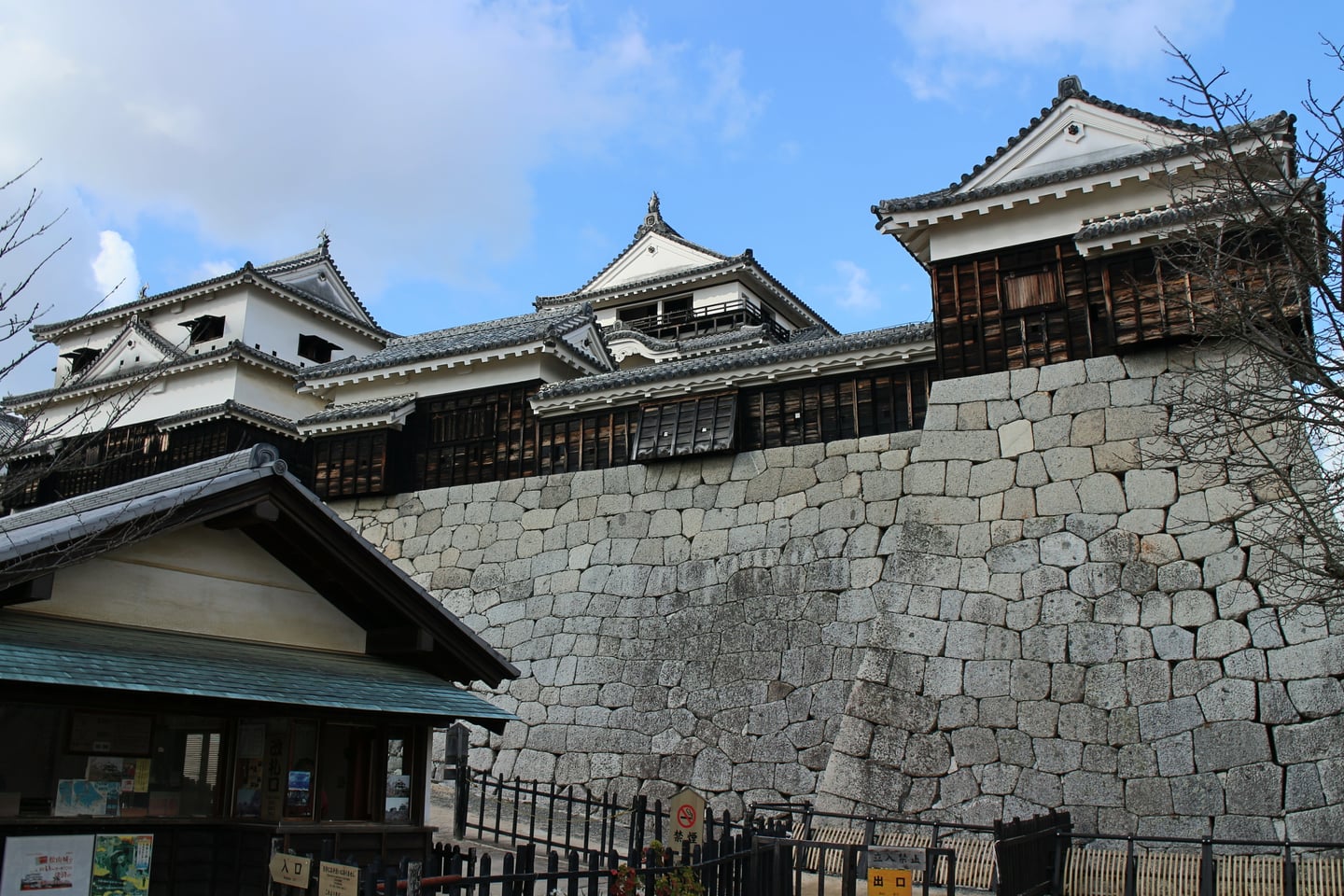 마쓰야마 마쓰야마 성, 거대한 석축 위에 웅장하게 솟아오른 전통 성곽 건물이 푸른 하늘과 어우러진 풍경입니다.