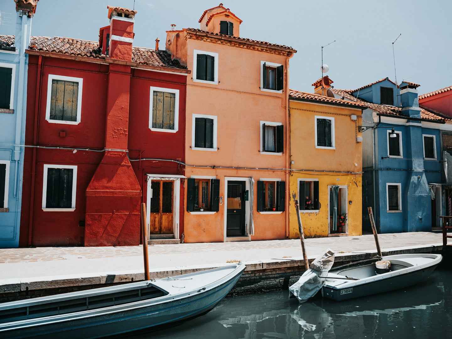 베니스 부라노섬, 운하를 따라 늘어선 알록달록한 원색의 집들과 물 위에 떠 있는 작은 보트들이 어우러진 이국적인 풍경입니다.