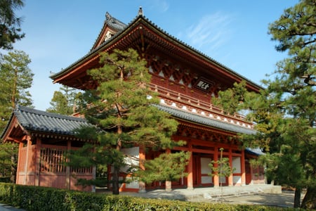교토 다이토쿠지, 푸른 소나무 사이로 위엄 있게 서 있는 붉은색 2층 목조 산몬과 전통 기와지붕의 조화로운 풍경입니다.