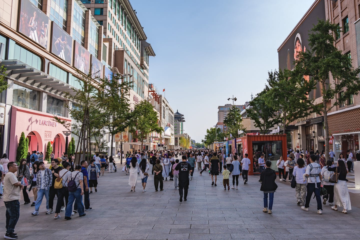 베이징 왕부정 거리, 현대적인 쇼핑몰과 브랜드 매장 사이로 수많은 사람들이 활기차게 걷고 있는 보행자 전용 도로의 전경입니다.