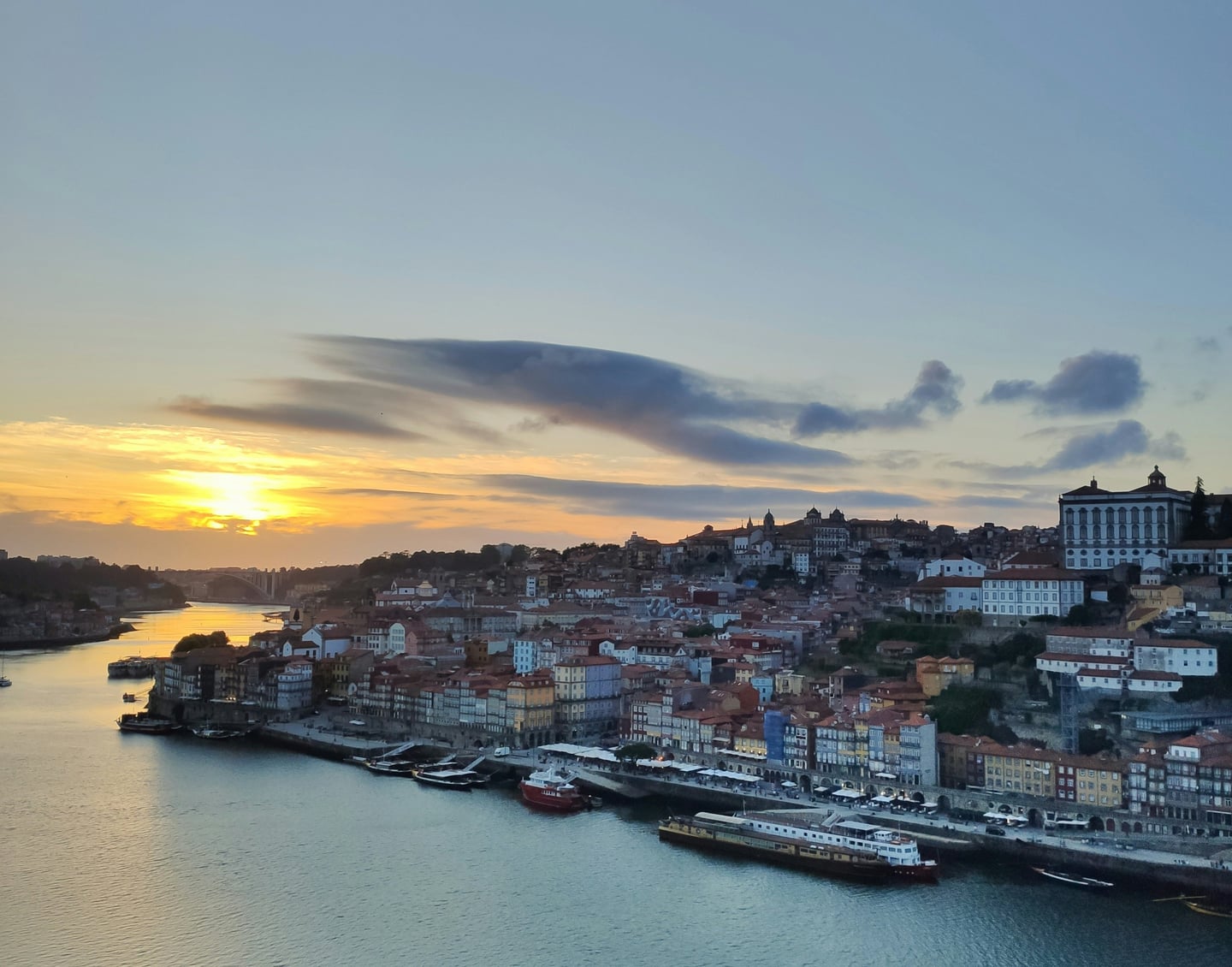 포르투 모루 정원, 황금빛 일몰이 도루 강변의 리베이라 지구와 고풍스러운 건축물들을 따스하게 감싸는 환상적인 저녁 풍경입니다.