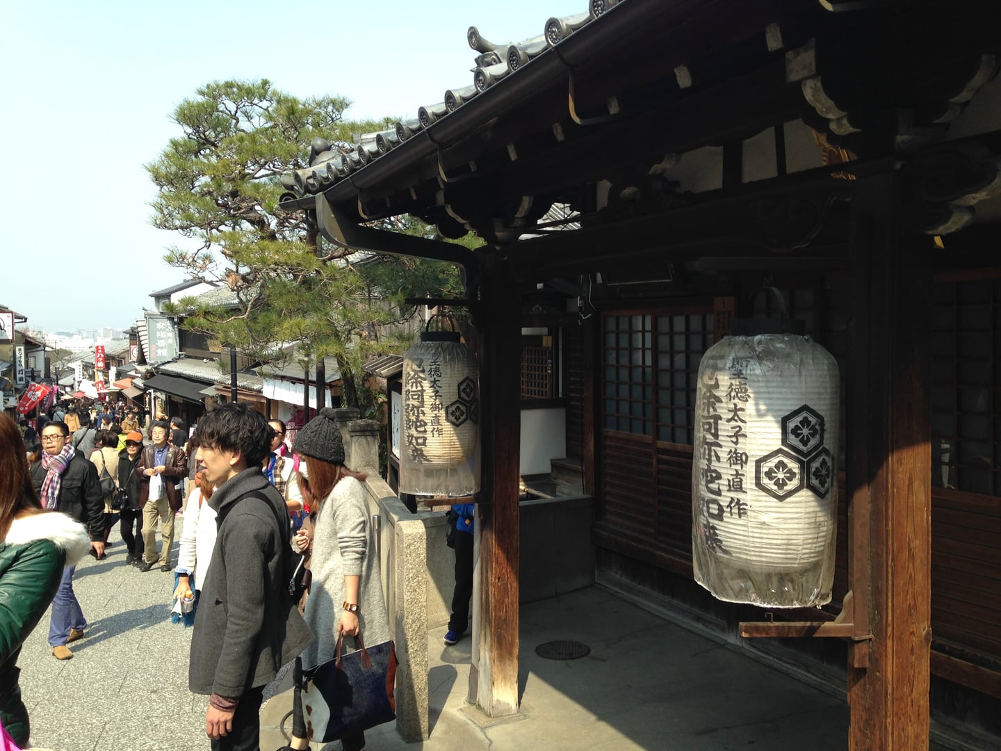 교토 키요미즈자카, 전통적인 목조 가옥과 커다란 제등이 걸린 언덕길을 따라 걷는 관광객들의 활기찬 모습.