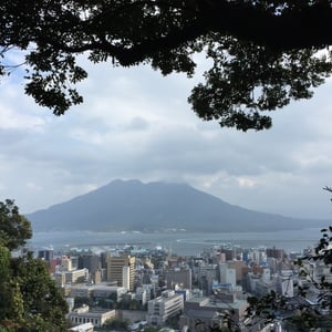 가고시마 가고시마 중앙역, 푸른 하늘 아래 아뮤플라자 옥상의 거대한 빨간색 대관람차가 돋보이는 역 광장 전경입니다.