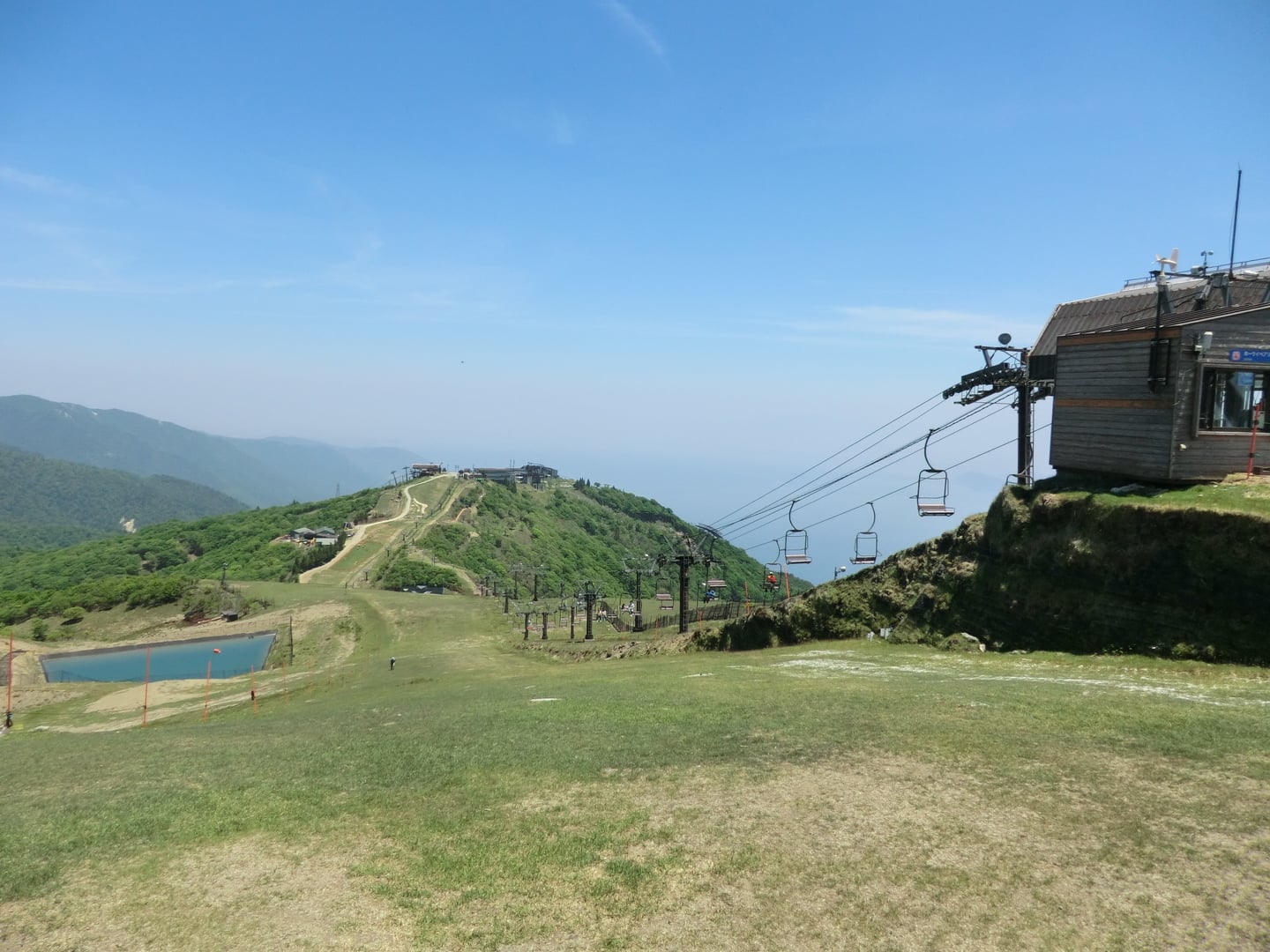 오쓰 비와코 밸리 로프웨이, 푸른 산등성이를 따라 이어지는 리프트와 탁 트인 산 정상의 파노라마 전경입니다.