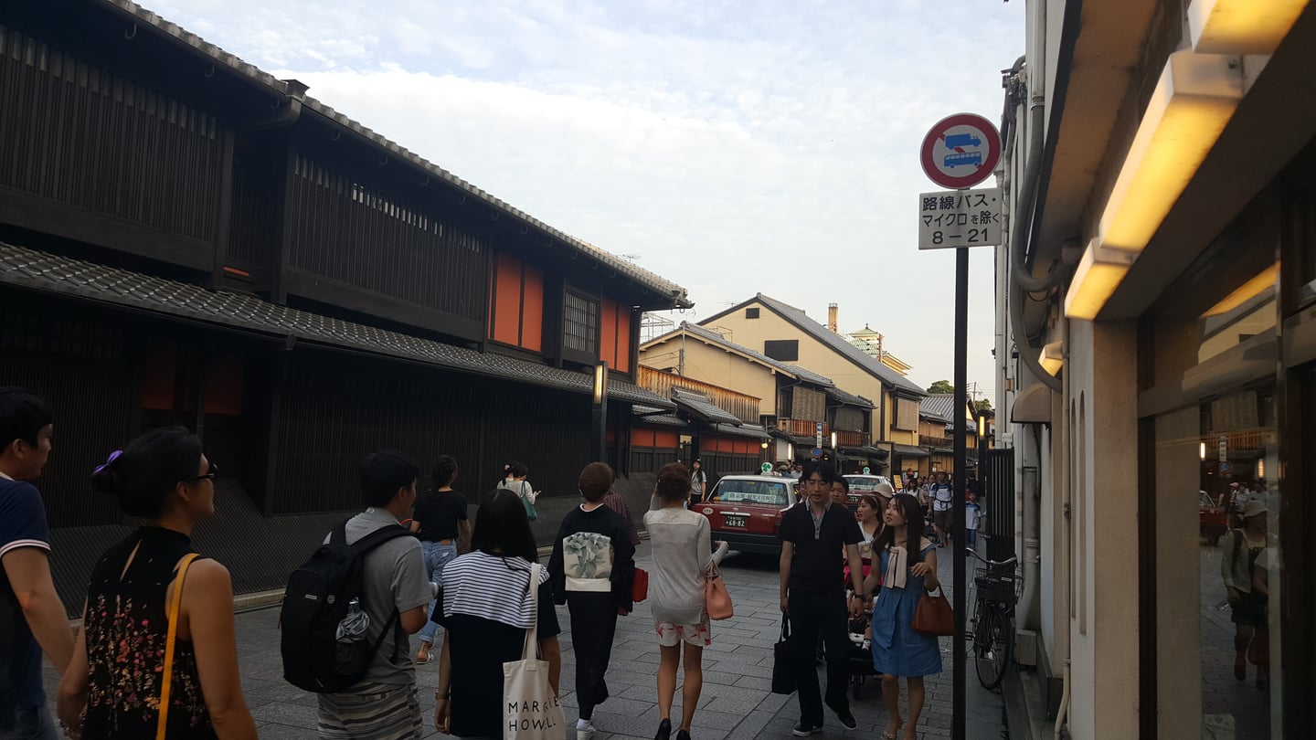 교토 하나미코지, 전통적인 목조 가옥이 늘어선 고풍스러운 거리에서 산책을 즐기는 관광객들의 활기찬 모습입니다.