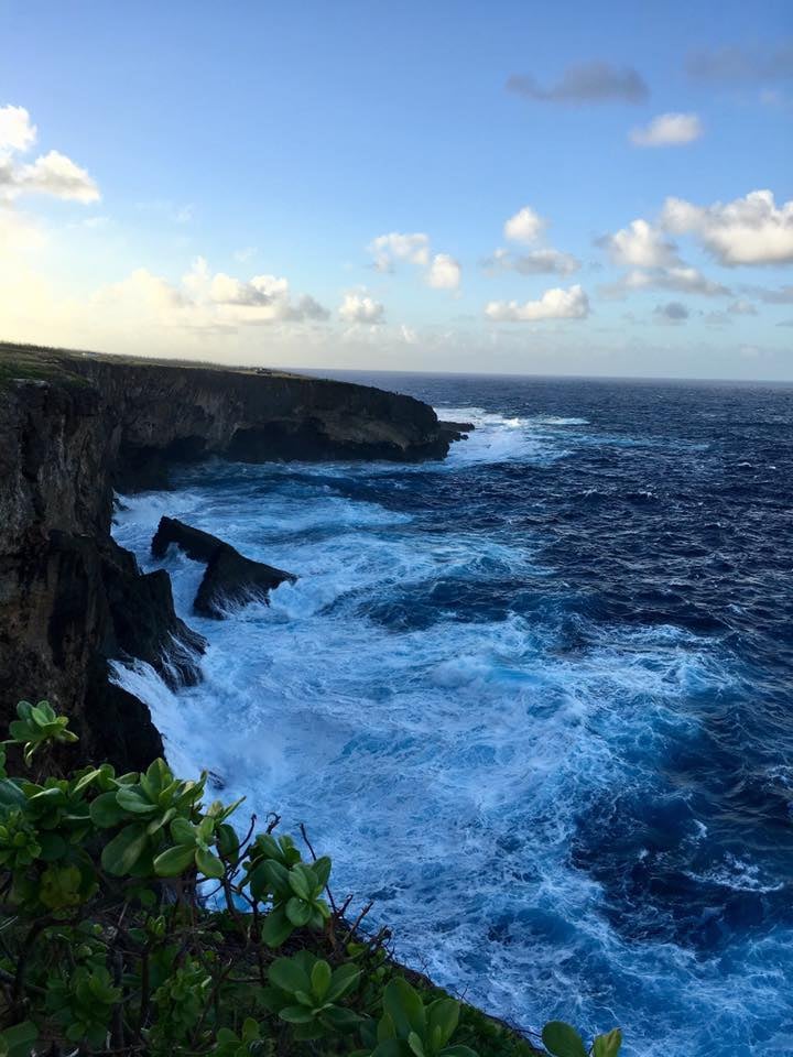 사이판 만세절벽, 웅장한 해안 절벽 아래로 푸른 바다의 거친 파도가 하얗게 부서지며 장관을 이루는 풍경입니다.