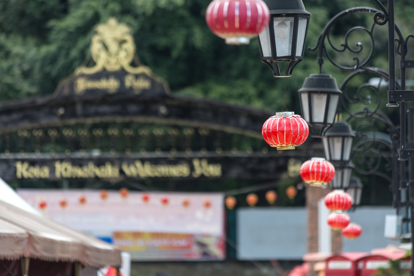 코타키나발루 제셜턴 포인트, 환영 문구가 적힌 아치형 입구와 붉은 등불이 어우러진 항구의 이국적인 풍경입니다.