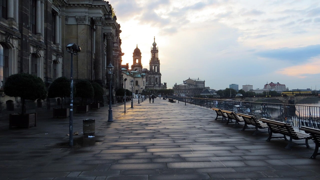 드레스덴 브륄의 테라스, 노을 지는 하늘 아래 엘베 강변 산책로와 고풍스러운 유럽 건축물이 자아내는 평화로운 저녁 풍경입니다.