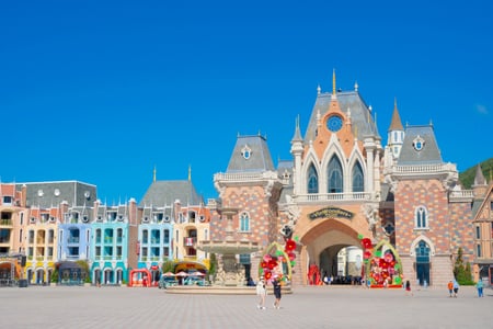 나트랑 빈원더스 무비 캐슬, 푸른 하늘 아래 화려한 유럽풍 성채와 분수대가 어우러진 광장의 이국적인 풍경입니다.