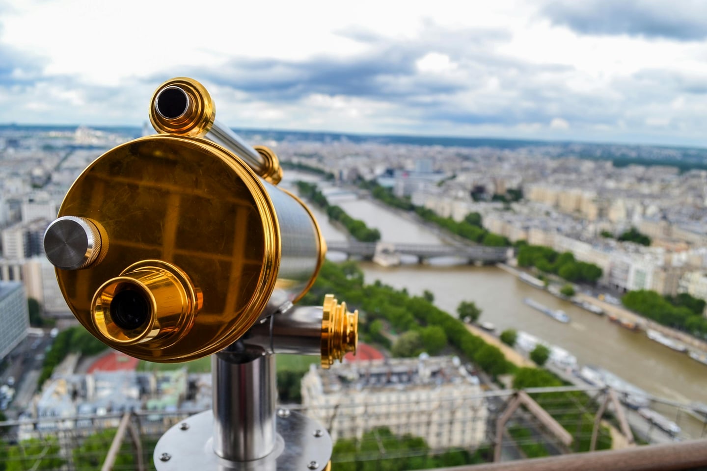 파리 에펠탑 전망대, 황금빛 망원경 너머로 굽이치는 세느강과 파리 시내의 이국적인 풍경이 한눈에 들어오는 탁 트인 전경입니다.