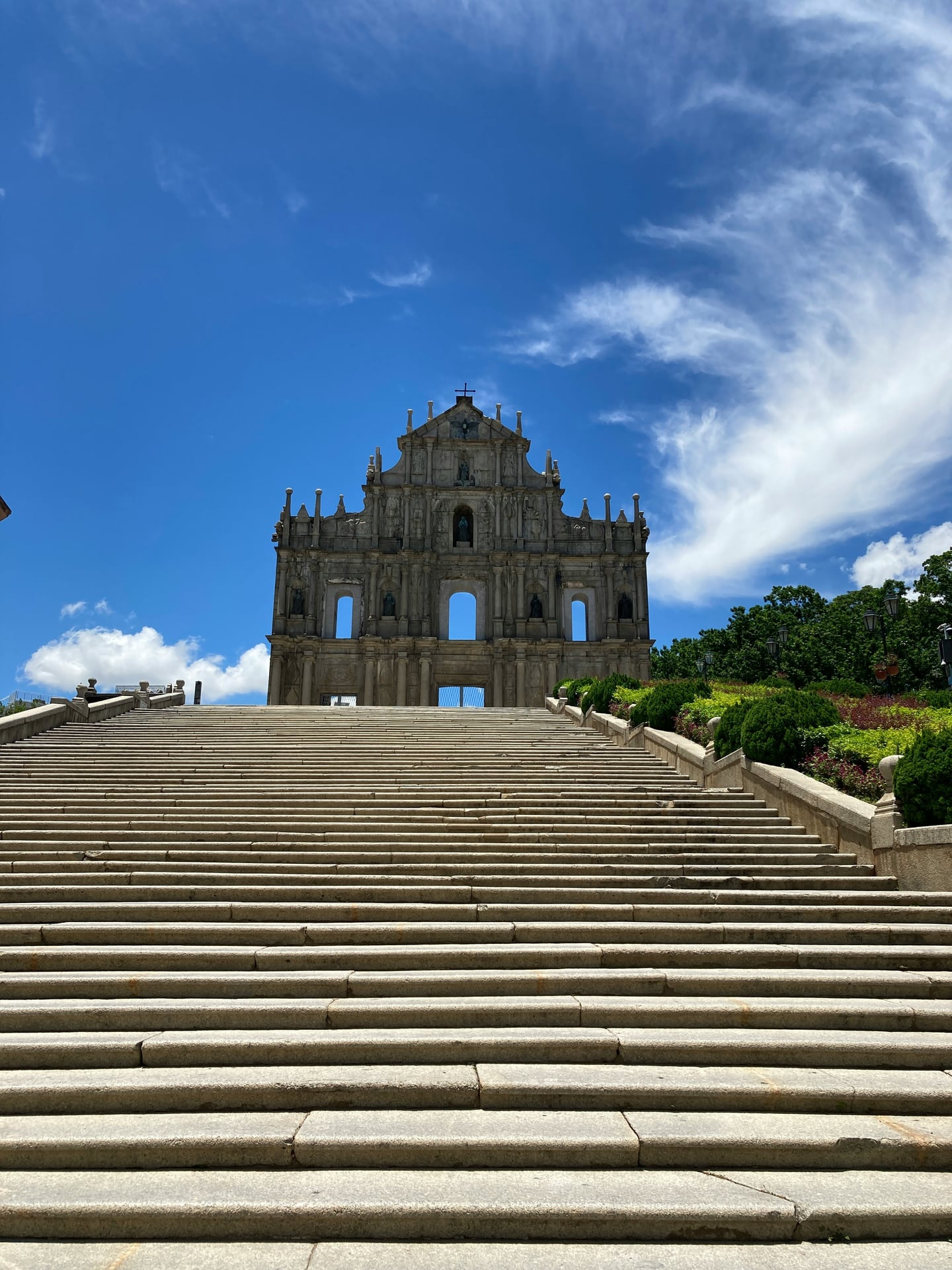 마카오 성 바울 성당 유적, 웅장한 석조 파사드와 하늘을 향해 길게 이어진 넓은 돌계단이 어우러진 역사적인 풍경입니다.