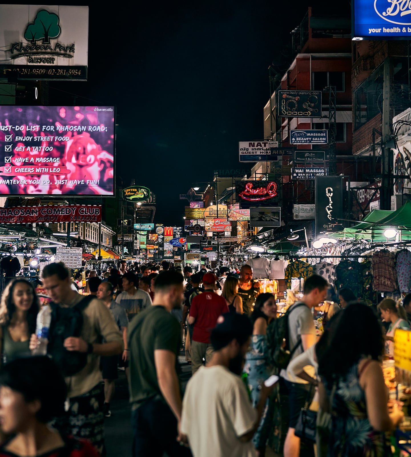 방콕 카오산 로드, 화려한 네온사인 아래 수많은 인파로 북적이는 활기찬 밤거리의 야시장 풍경입니다.