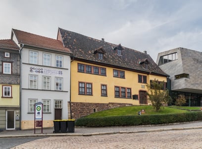 아이제나흐 바흐 하우스, 노란색 전통 가옥과 현대적 박물관 건물이 나란히 서 있는 역사적인 생가의 평화로운 풍경입니다.