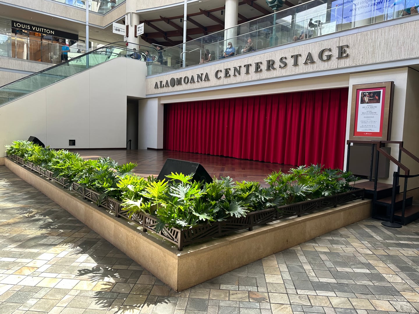 하와이 알라모아나 쇼핑센터, 붉은 커튼이 드리워진 야외 공연장 센터스테이지와 주변의 세련된 쇼핑몰 전경입니다.