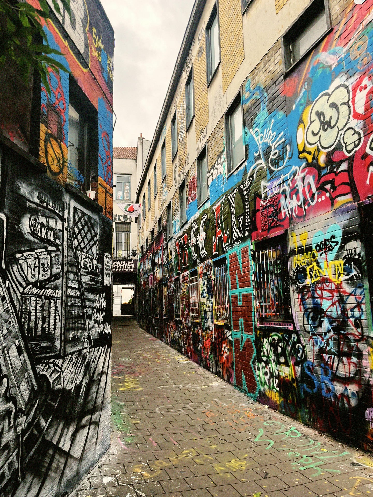 겐트 그라피티 거리, 좁은 골목길 양쪽 벽면을 가득 채운 화려하고 다채로운 거리 예술가들의 페인팅 작품들이 인상적인 풍경입니다.