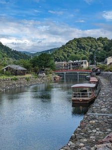 우지 우지강 유람선, 맑은 하늘 아래 붉은 다리와 정박한 전통 유람선들이 어우러진 평화로운 강변 풍경입니다.