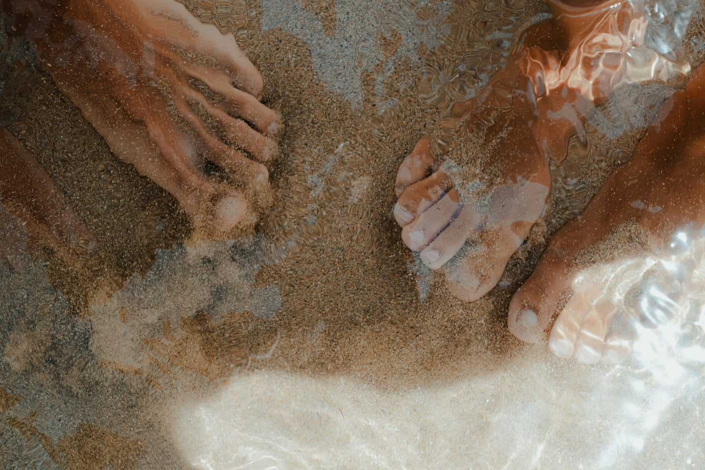 벳푸 카마도 지옥 족욕탕, 맑은 온천수 아래 고운 모래가 깔린 바닥에서 족욕을 즐기는 발의 모습.