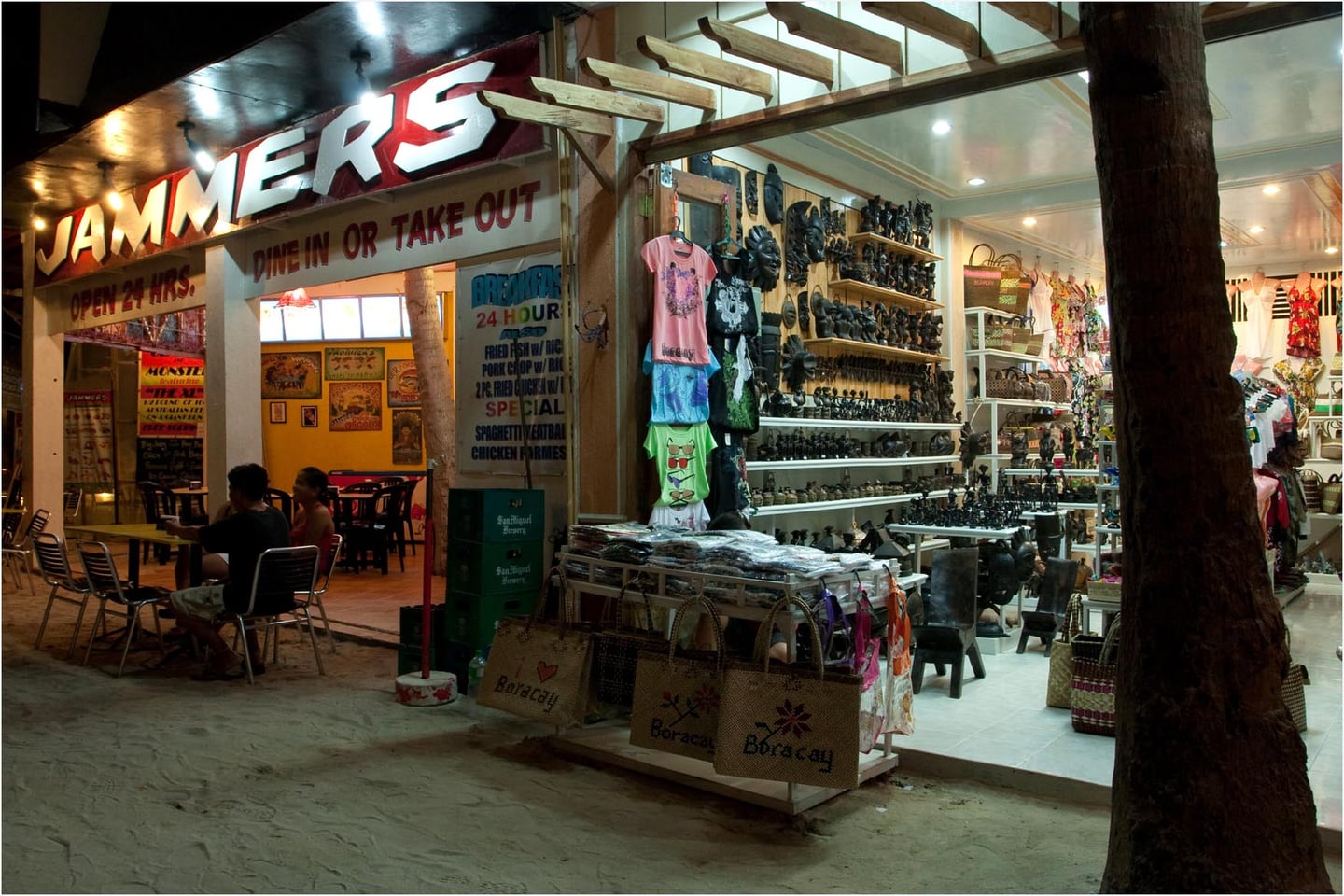 보라카이 디몰, 밤거리를 밝히는 재머스 식당과 아기자기한 기념품들이 가득 진열된 상점의 활기찬 야경 모습입니다.