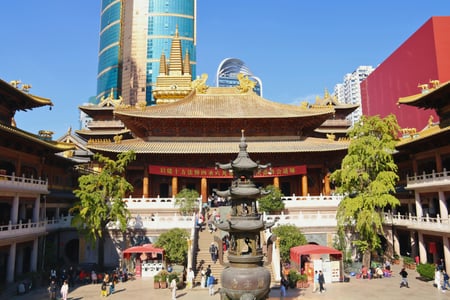 상하이 징안사, 현대적인 고층 빌딩 숲 사이에서 황금빛 지붕을 뽐내며 위엄 있게 서 있는 전통 사찰의 전경입니다.