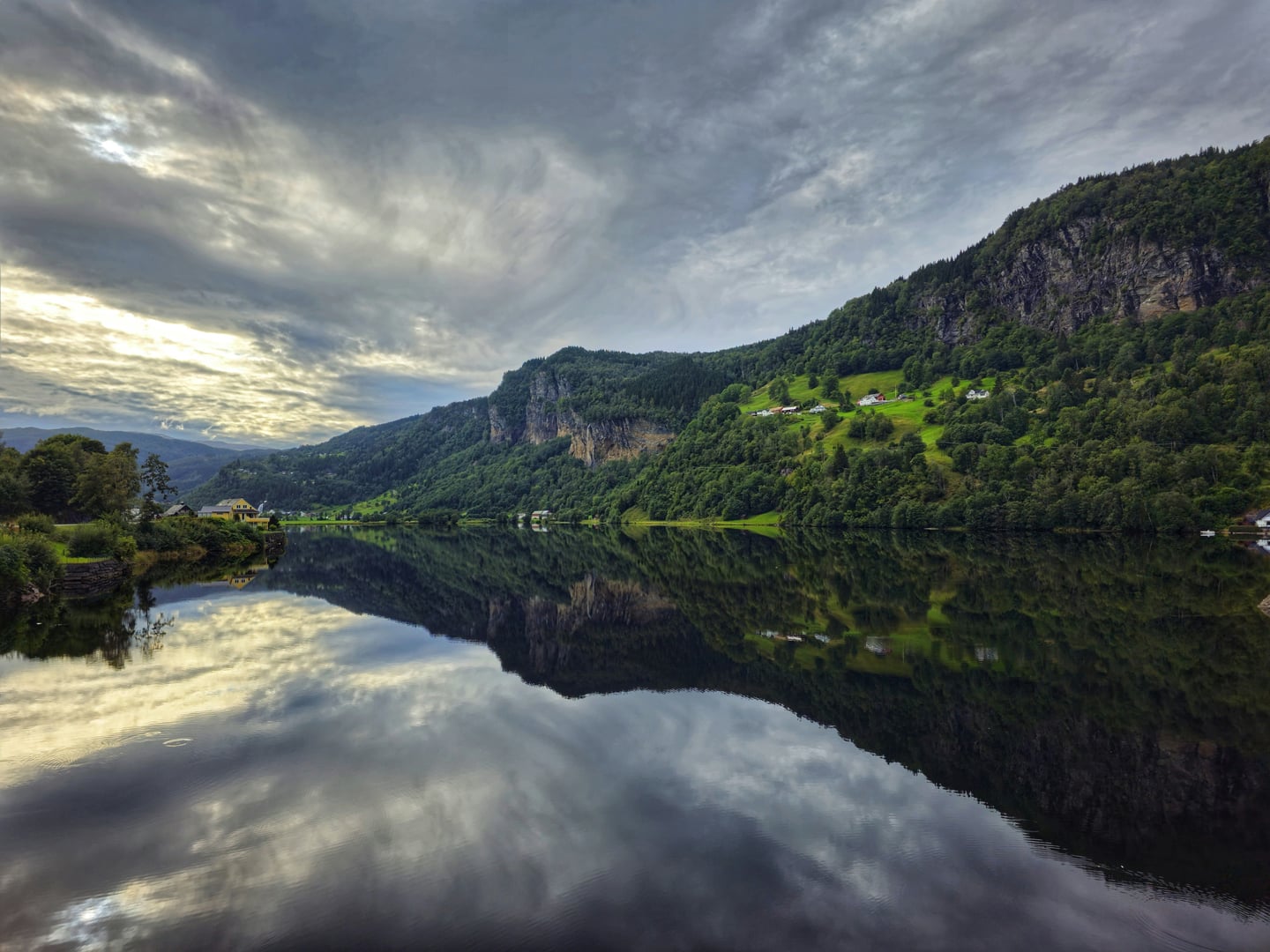 스타방에르 하르당에르, 거울처럼 맑은 호수면에 반사된 울창한 산맥과 평화로운 마을이 어우러진 노르웨이의 대자연 풍경입니다.