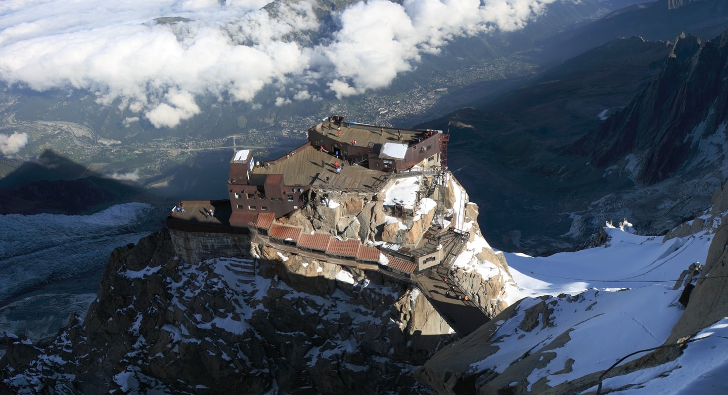 샤모니 에귀디미디, 험준한 암벽 끝에 위치한 전망대 테라스에서 내려다본 구름 위 알프스 산맥과 샤모니 마을의 웅장한 파노라마 뷰입니다.