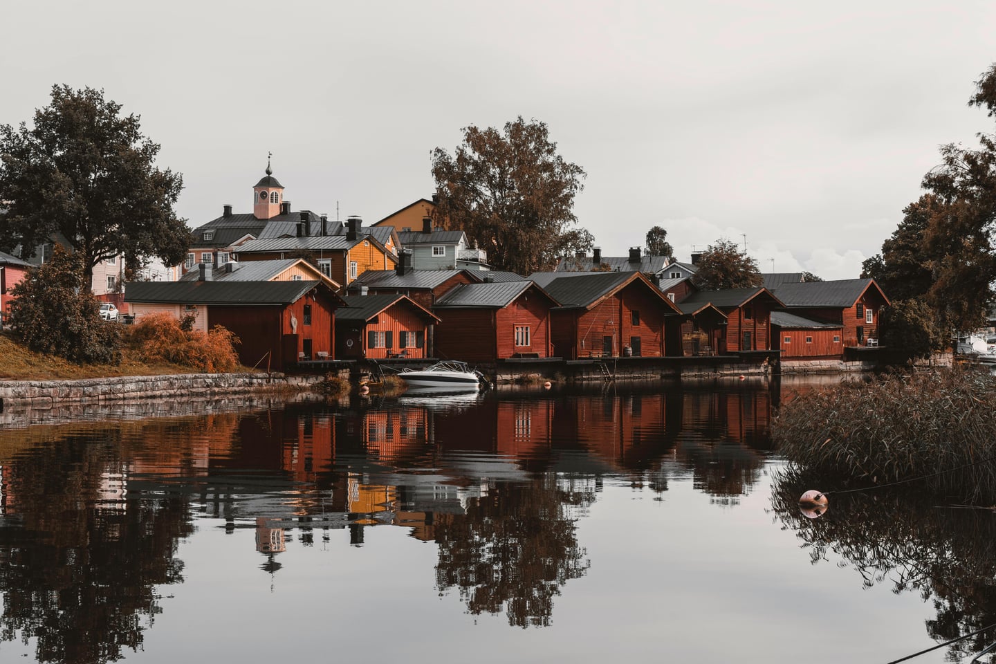 포르보 포르보 올드 타운, 강변을 따라 늘어선 붉은 목조 가옥들이 잔잔한 물결 위로 아름답게 투영되는 고즈넉한 풍경입니다.